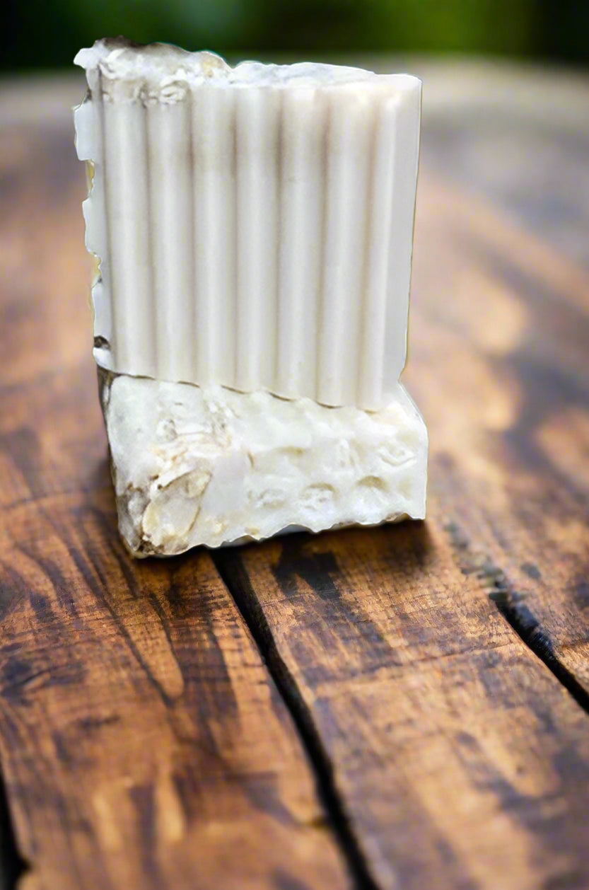 Bar of white soap with a textured surface on a wooden surface